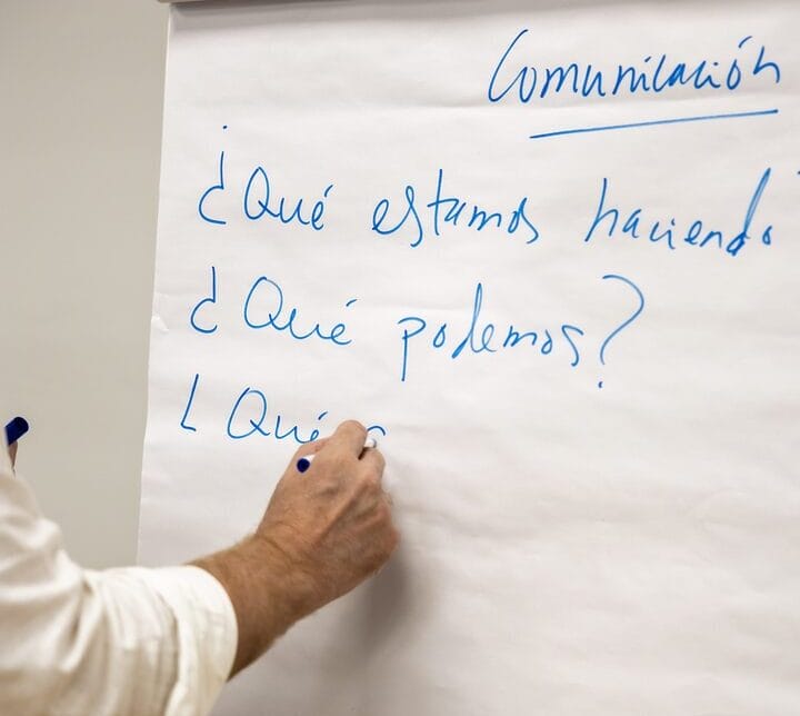 Primer plano de una persona escribiendo en pizarra de papel aspectos de emprendimiento en relación al startup pivot.