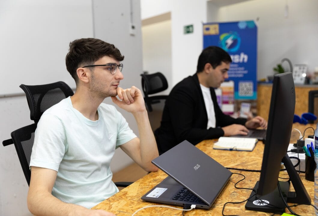 Emprendedor joven sentado en una oficina frente a su ordenador trabajando.